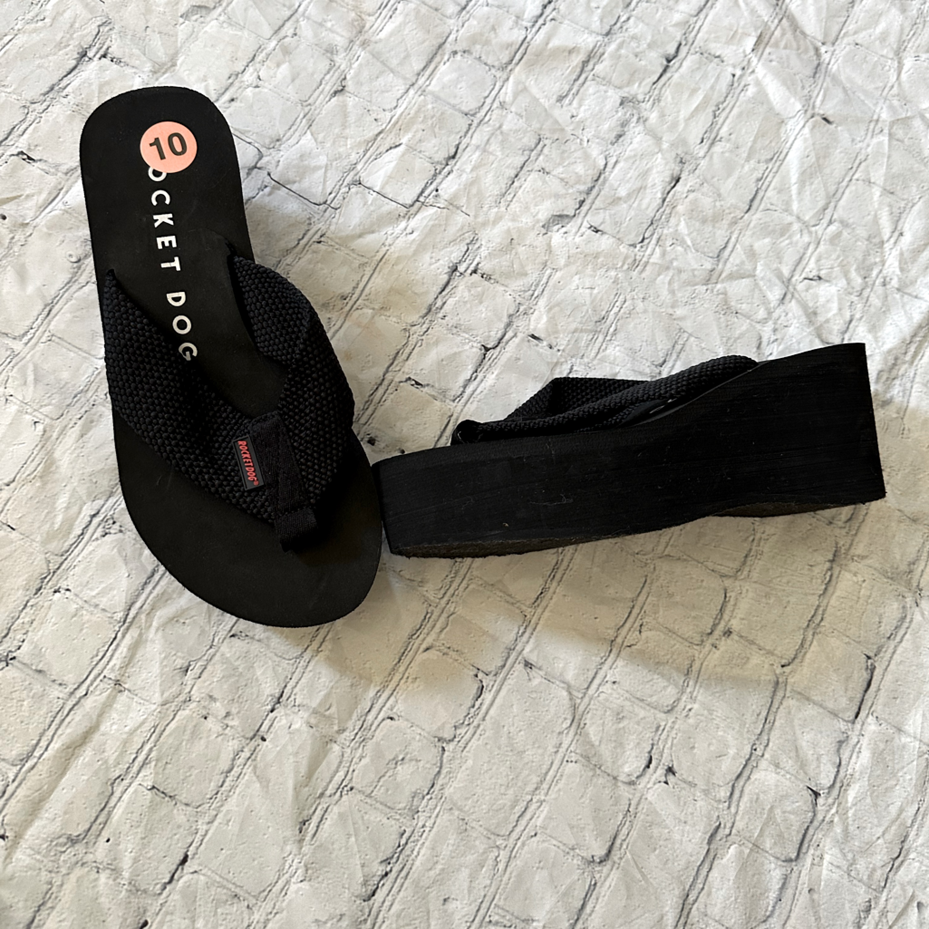 Rocket Dog black platform flip-flops with a thick wedge sole, sitting on a light background
